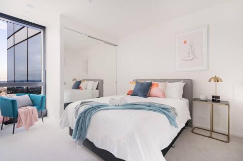 a white bedroom with a large bed and a window at Modern 1BR Apt in Southbank #Australia108#AU4408 in Melbourne