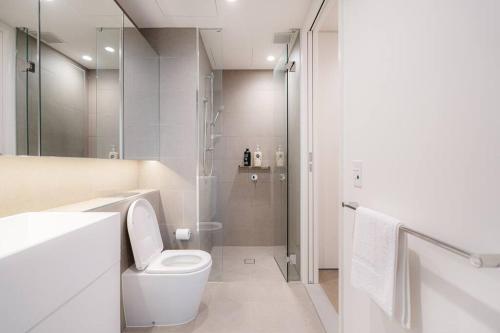 a white bathroom with a toilet and a shower at Modern 1BR Apt in Southbank #Australia108#AU4408 in Melbourne
