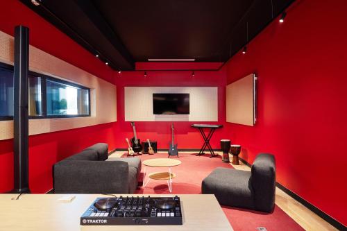 a red room with a desk and chairs and a keyboard at Hife Toulouse Sud Labège in Labège