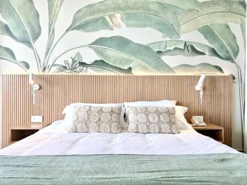 1 dormitorio con 1 cama con un gran mural en la pared en Banana Leaf Beachfront Exotic Room in Batroun, 