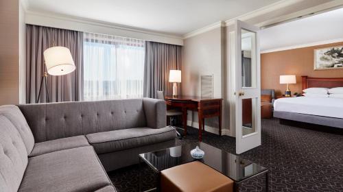 a hotel room with a couch and a bed and a desk at Hilton Short Hills in Short Hills