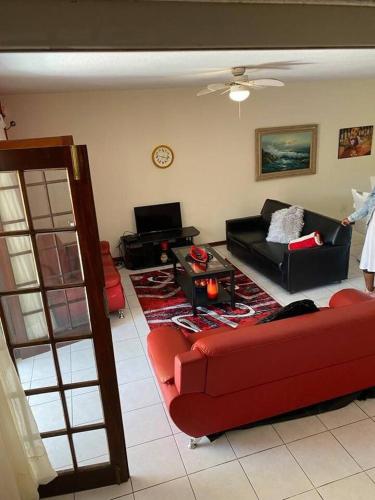 a living room with a red couch and a table at Off-shore Guest house in Margate