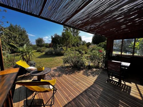 a patio with a table and chairs on a wooden deck at Le Petit Bergeron in Mazion