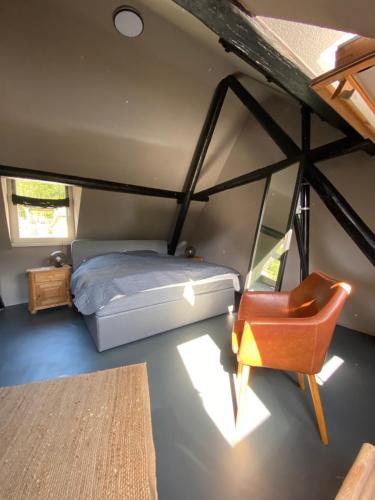 ein Schlafzimmer mit einem Bett und einem Stuhl in einem Zimmer in der Unterkunft Ferienhaus Fridolin in Zell an der Mosel