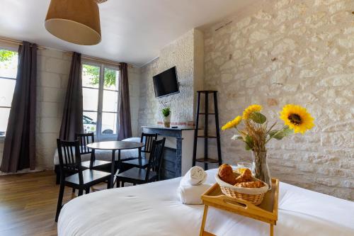 une chambre avec un lit avec un vase de fleurs sur une table dans l'établissement L'Authentic, à Saint-Aignan