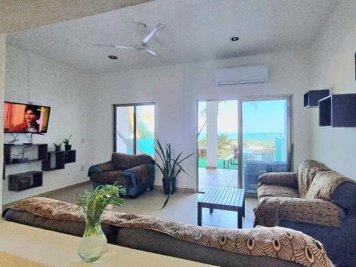 a living room with two couches and a tv at On The Beach - Seaside Sunrise Haven 3 Bedrooms SEA VIEW in Cancún