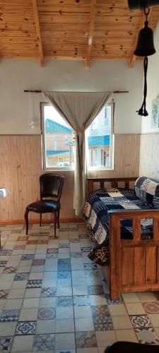 ein Schlafzimmer mit einem Bett, einem Stuhl und einem Fenster in der Unterkunft Cabaña El Pazo in Sierra de la Ventana