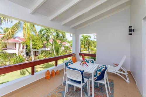patio con mesa y sillas en el balcón en Antigua Village- Villa Lilly 33B, en Dickenson Bay
