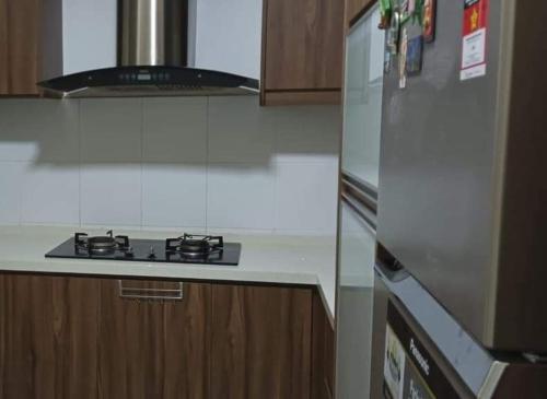 Il comprend une cuisine équipée d'une cuisinière et d'un réfrigérateur. dans l'établissement D CAMYLIA PUTRAJAYA HOMESTAY, à Putrajaya