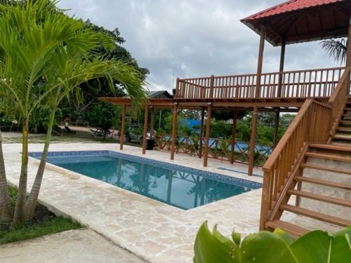 - une piscine avec un pavillon en bois et une terrasse dans l'établissement Cabaña Higueron Tennis Club, à Turbaco