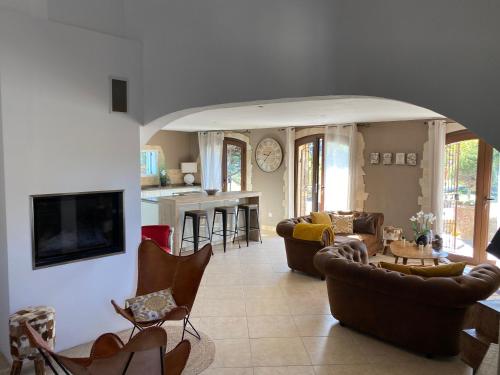 a living room with couches and chairs and a kitchen at Le Hameau des vanades in Ampus