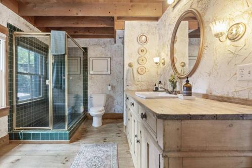 ein Bad mit einer Dusche, einem Waschbecken und einem Spiegel in der Unterkunft Owl Pine Cabin on Strawberry Creek in Idyllwild