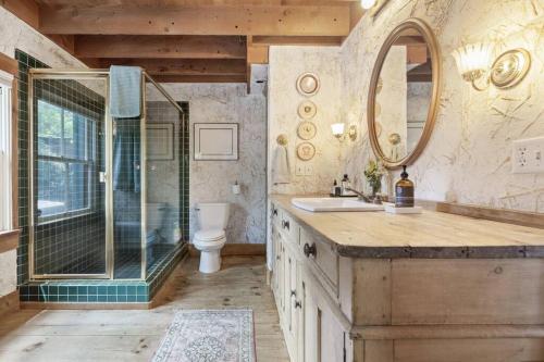 a bathroom with a shower and a sink and a mirror at Owl Pine Cabin on Strawberry Creek in Idyllwild