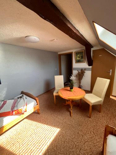 een kamer met een tafel en stoelen en een bed bij Pension 2 Ferienhof Hanstorf in Satow