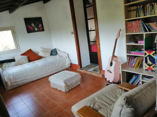 ein Wohnzimmer mit einem Sofa und einer Gitarre in der Unterkunft Les combes in Montarnaud