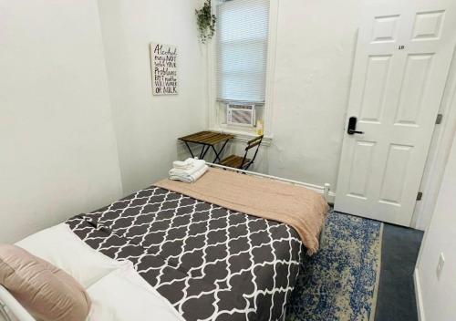a bedroom with a black and white bed and a window at Oui on Ludlow - Entire House and Private Rooms in University City in Philadelphia