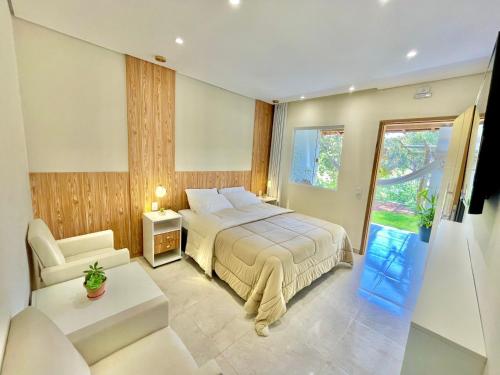 a bedroom with a bed and a chair and a window at Estalagem Cachoeira do Pimenta in Cunha