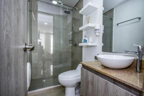 y baño con aseo, lavabo y ducha. en APARTAMENTO OCEAN DRIVE 410 CARTAGENA, en Cartagena de Indias