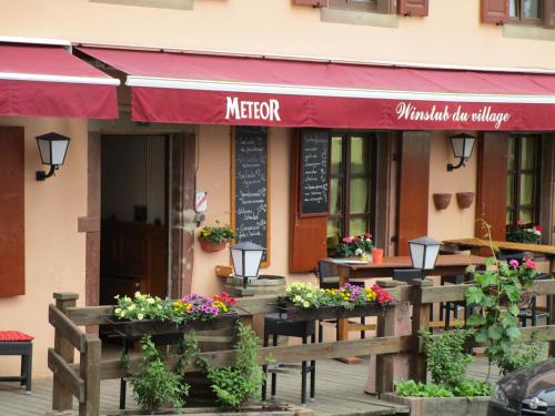 RorschwihrにあるLocation Chez Helmutの目の前にテーブルと花が飾られたレストラン