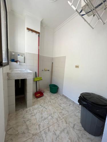 a bathroom with a sink and a trash can at Apartamento Vacacional Cartagena Colombia in Cartagena de Indias