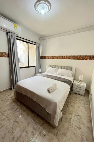 Un dormitorio con una cama grande y una ventana en Apartamento Vacacional Cartagena Colombia en Cartagena de Indias