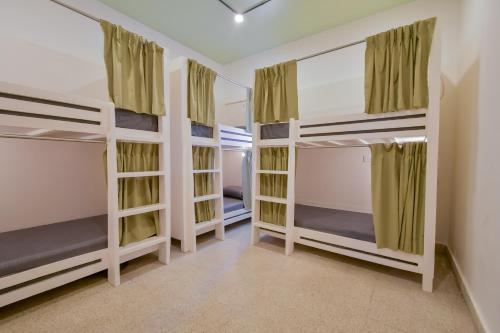 a bedroom with three bunk beds in a room at Snore Summore, Hostel in Koramangala in Bangalore