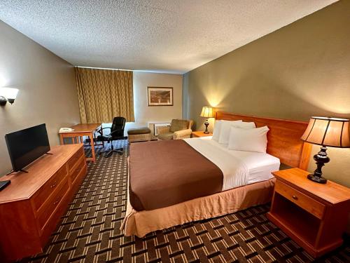 FairBridge Inn & Suites - Lewiston في لويستون: غرفة في الفندق مع سرير ومكتب