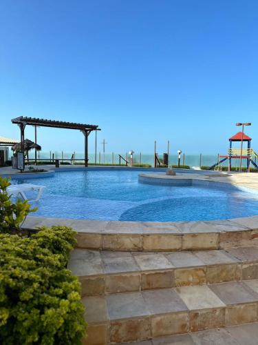 a swimming pool with a playground in the background at Apto 2 quartos - Condomínio Frente Mar in Beberibe