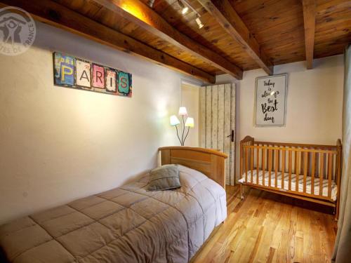 ein Schlafzimmer mit einem Bett und einem Babybett in der Unterkunft Gîte Belmont-de-la-Loire, 4 pièces, 5 personnes - FR-1-496-126 in Belmont-de-la-Loire
