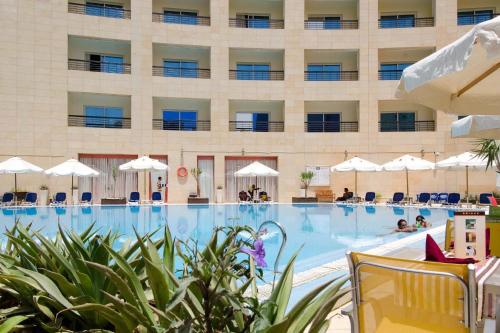 a pool in front of a hotel at Swiss Inn Teda Hotel & Aqua Park in Ain Sokhna