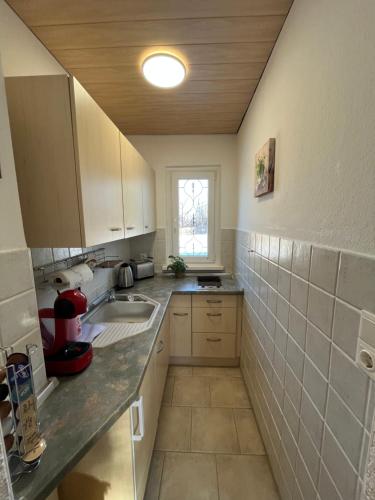 a small kitchen with a sink and a window at Ferienhaus Waldoase in Ilsenburg