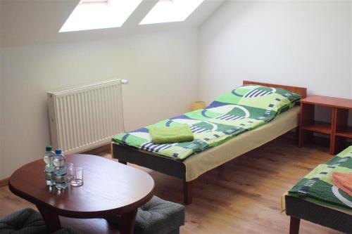 Kleines Zimmer mit 2 Betten und einem Tisch in der Unterkunft Dom Na Leśnej Górze in Leśna