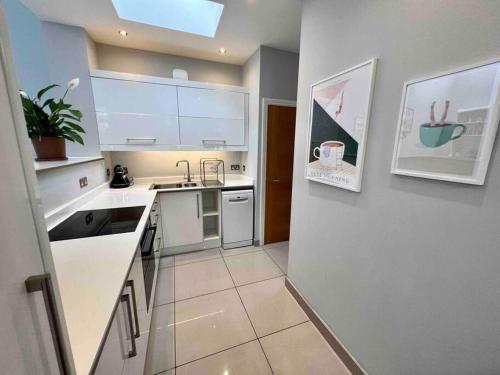 a small kitchen with white counters and a sink at Private garden oasis in central Bristol in Bristol