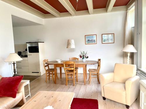 kuchnia i salon ze stołem i krzesłami w obiekcie Appartement Opa's Huisje w mieście Ruinerwold