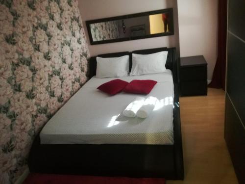 卡帕里卡海岸的住宿－Apartamento Da Costa，一间卧室配有一张带两个红色枕头的床