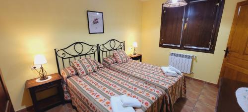 a bedroom with a bed and two lamps and a window at Apartamentos Rurales Argame in Argamé