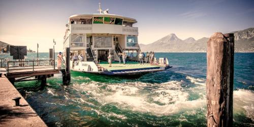 a boat is docked at a dock in the water at Hotel Merano in Brenzone sul Garda