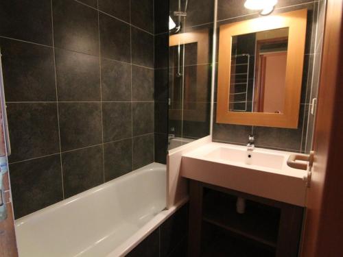 une salle de bain avec un lavabo, une baignoire et un miroir dans l'établissement Studio cosy 4 pers à l'Alpe d'Huez – Balcon sud, proche pistes et commerces, animaux acceptés - FR-1-405-152, à L'Alpe-d'Huez