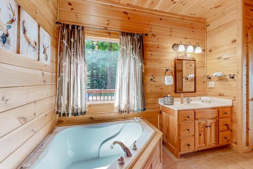 baño con bañera y lavamanos en una cabaña en Ken's Cabin, en Blue Ridge