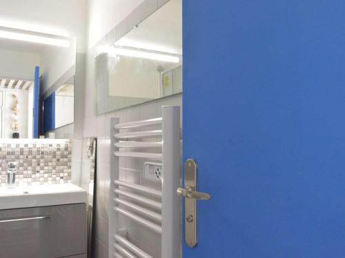 La salle de bains est pourvue d'un lavabo et d'une porte bleue. dans l'établissement Studio Cabine, Terrasse, Cap d'Agde - 4 Pers, Proche Plage et Commerces - FR-1-249-255, au Cap d'Agde