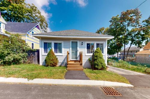 a white house with a blue door on a street at Cabin at the Beach in Old Orchard Beach