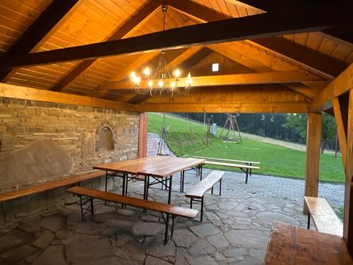 a wooden table and benches in a pavilion at Na Stoku in Istebna