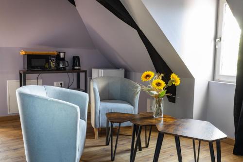 une chambre avec deux chaises et une table avec un vase de fleurs dans l'établissement La Suite Rubis, à Saint-Aignan