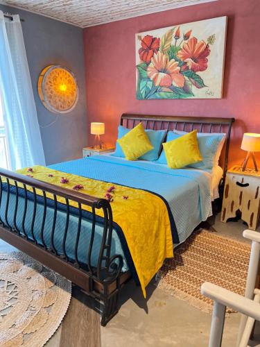a bedroom with a bed with blue sheets and yellow pillows at Villa Lulu Geribá in Búzios