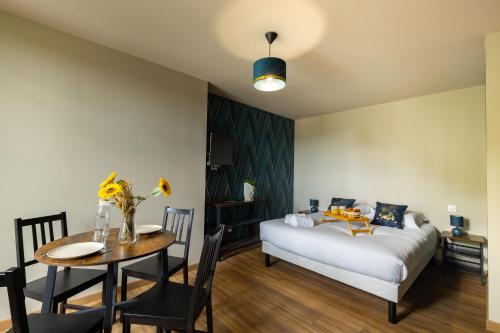 um quarto com uma cama, uma mesa e uma sala de jantar em L'Agate Bleue em Saint-Aignan