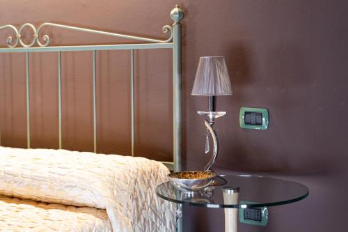 a bedroom with a bed with a table with a lamp at Residenza Villa Vecelli Cavriani in Mozzecane
