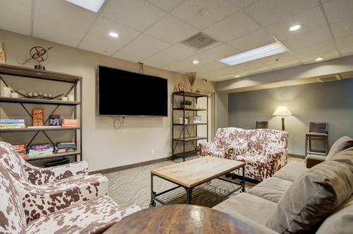 a living room with couches and a flat screen tv at Whitefish Riverfront Hotel in Whitefish