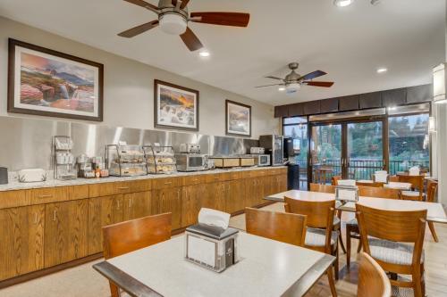 a restaurant with tables and chairs and a counter at Whitefish Riverfront Hotel in Whitefish