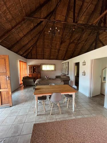 a living room with a wooden table and a couch at Vanross Bushveld Self Catering Accommodation in Maraheki