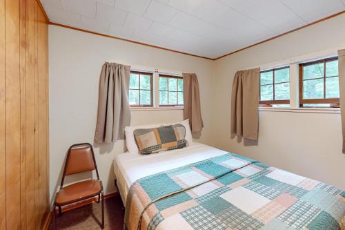 een slaapkamer met een bed en een stoel erin bij Ritter Cottage - Cabin #4 in Saint Germain
